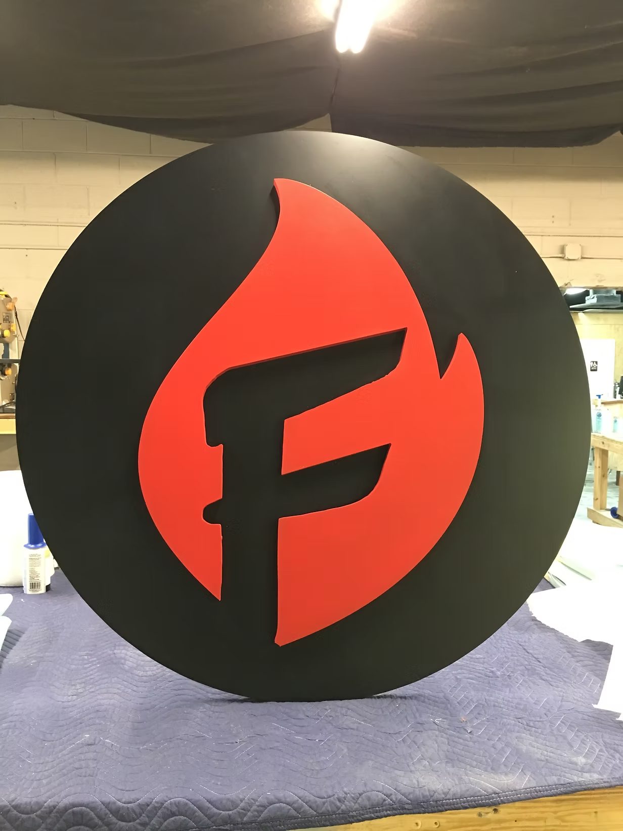 Custom Circular Logo Sign In Black Orange custom wood-look sign with carved and dimensional details
