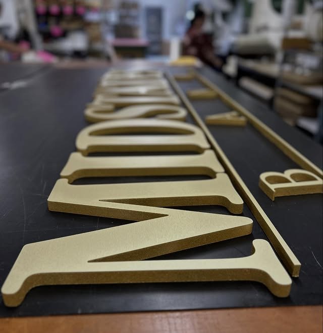 Gold Dimensional Serif Letters On Dark Panel custom wood-look sign with carved and dimensional details