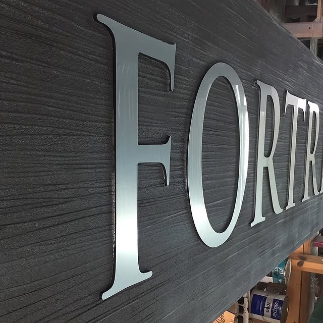 Silver Dimensional Letters On Woodgrain Panel custom wood-look sign with carved and dimensional details